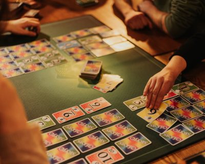 Quatres personnes jouent au jeu de société le "skyjo"
